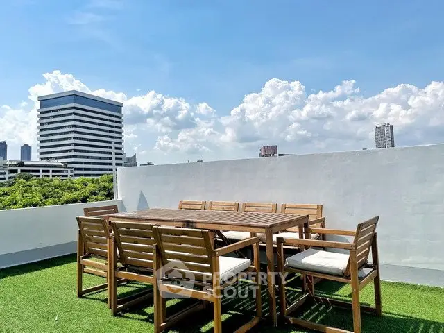 Stunning rooftop terrace with outdoor dining set and city skyline view.