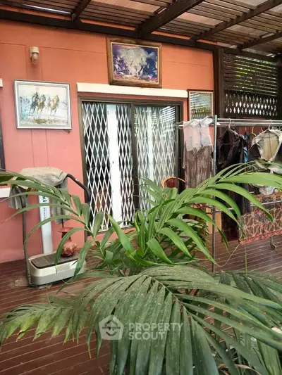 Charming patio with sliding doors and lush greenery, perfect for relaxation and outdoor living.