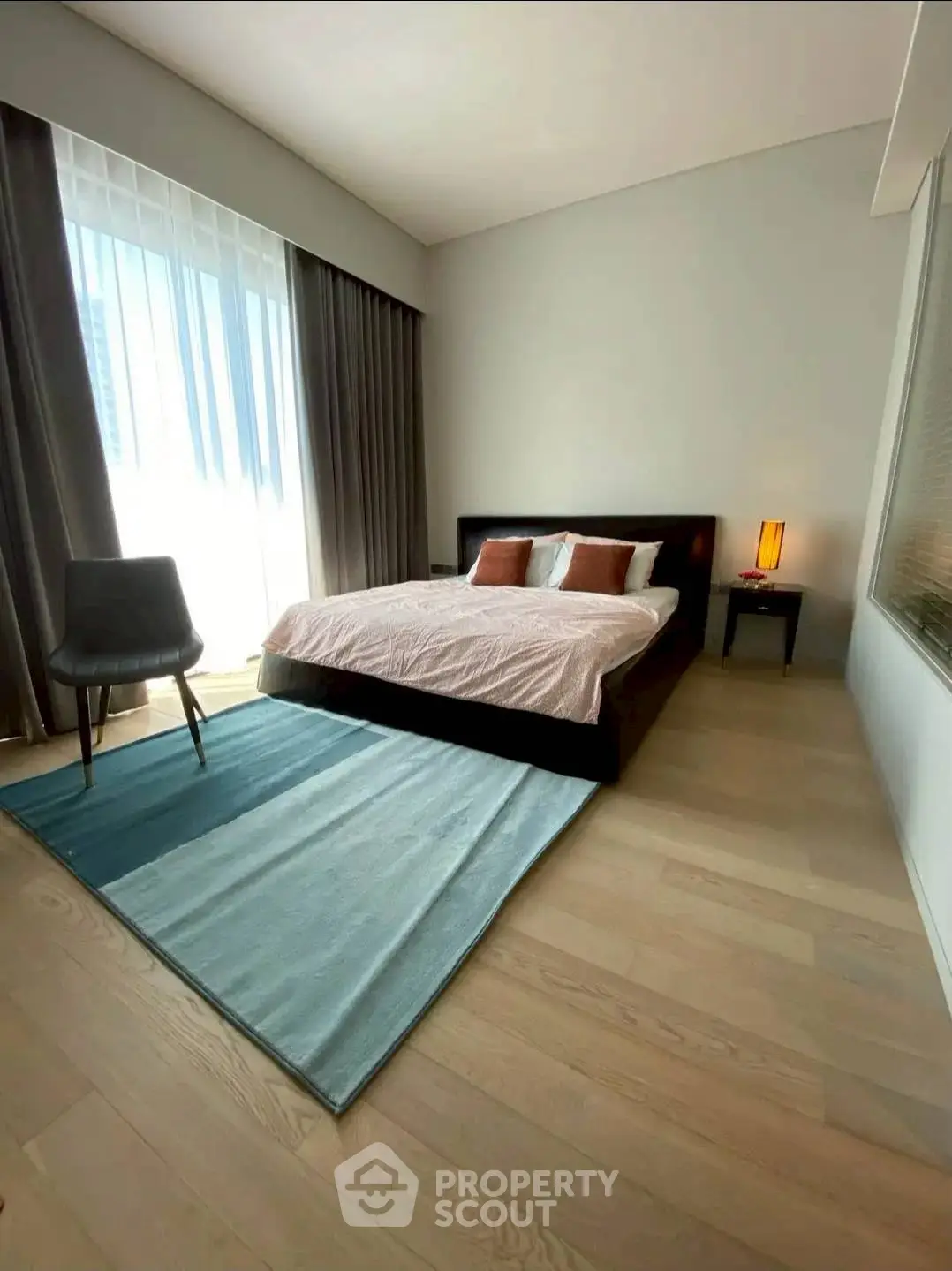 Modern bedroom with large window, stylish decor, and natural light.
