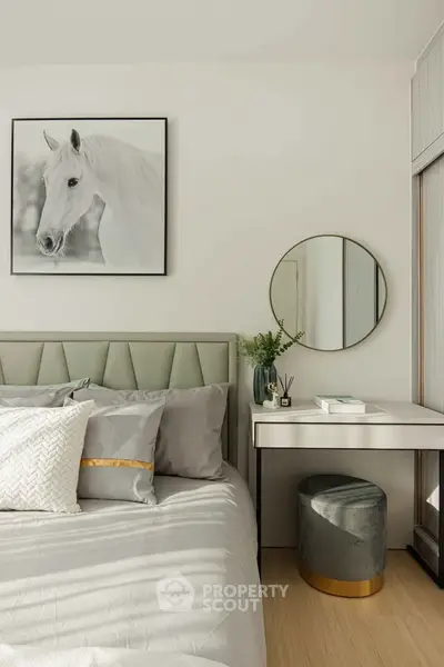 Elegant bedroom with stylish decor and modern furniture, featuring a horse artwork and a vanity mirror.