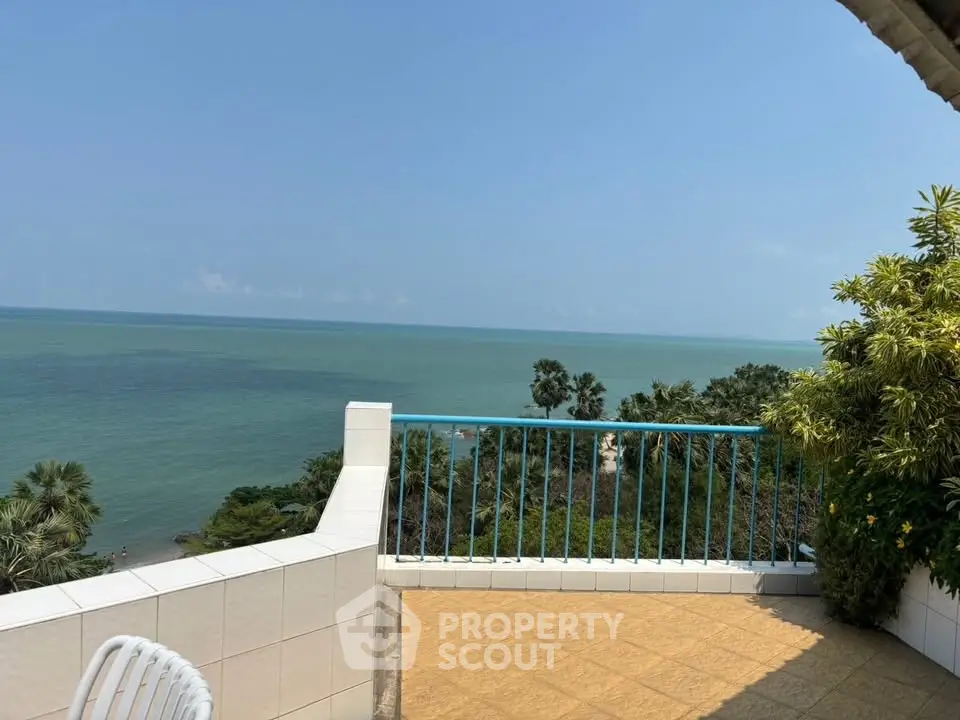 Stunning ocean view from spacious balcony with lush greenery, perfect for relaxation.