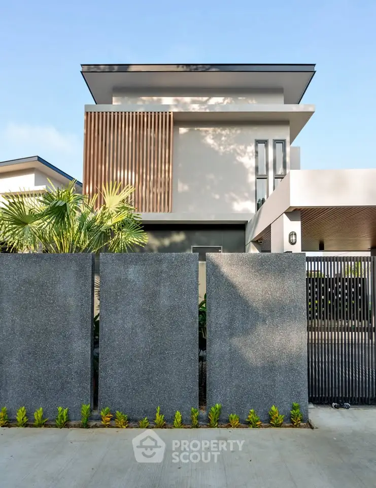 Modern two-story house with sleek design and lush greenery, featuring a stylish facade and contemporary architecture.