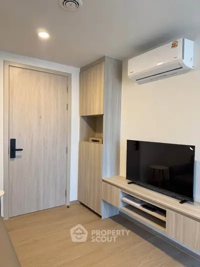Modern living room with sleek TV unit and air conditioning in a stylish apartment.