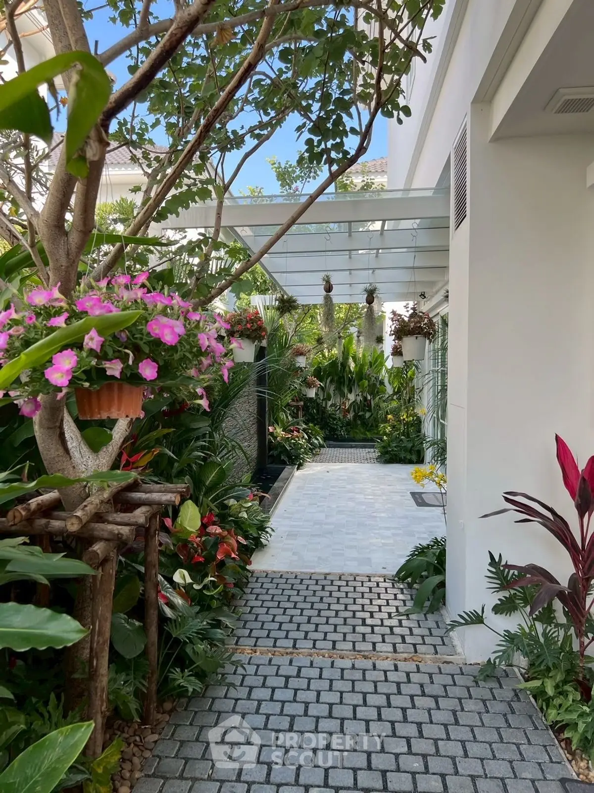 Charming garden pathway with lush greenery and vibrant flowers in a modern home exterior.
