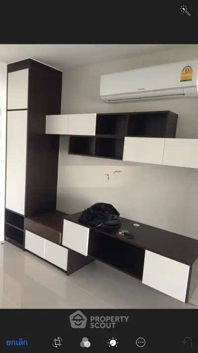 Modern living room with sleek built-in storage and air conditioning unit.