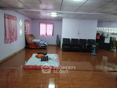 Spacious living room with tiled floor and simple furnishings