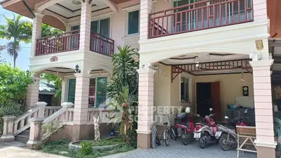 Charming two-story house with spacious balcony and lush greenery, perfect for family living.