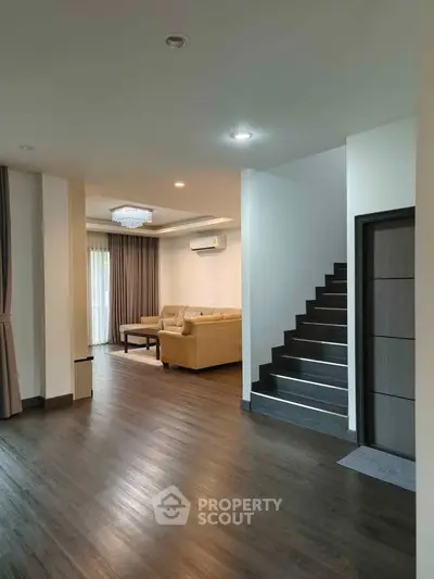 Spacious living room with elegant staircase and modern decor