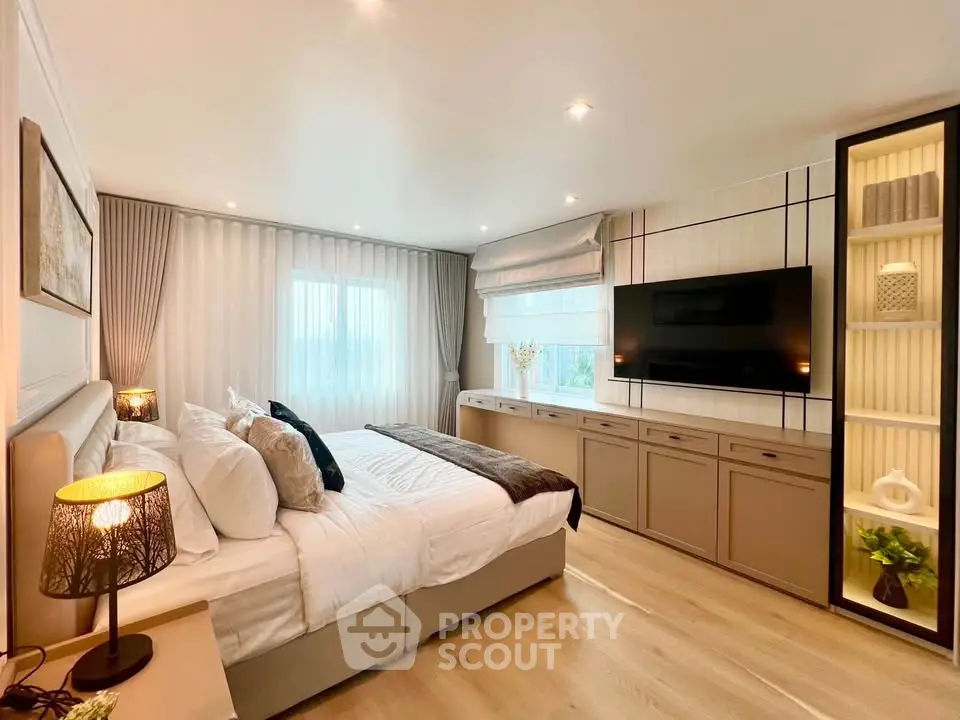 Luxurious bedroom with modern decor, large windows, and ambient lighting