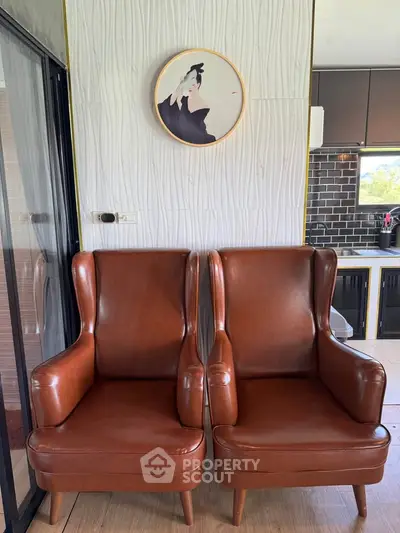 Stylish modern kitchen with leather armchairs and elegant wall art, perfect for contemporary living.