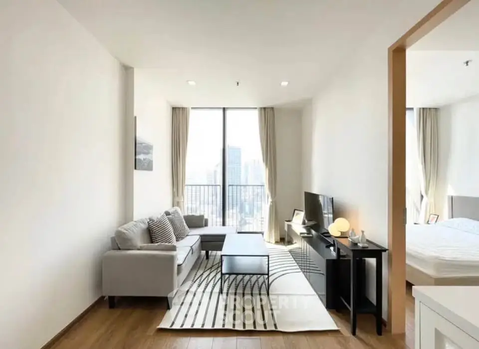 Modern living room with city view, stylish furniture, and natural light in a high-rise apartment.