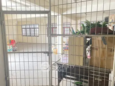 Spacious storage area with secure metal gate and ample natural light