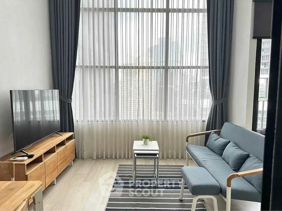 Modern living room with high ceilings and large windows in a stylish apartment.