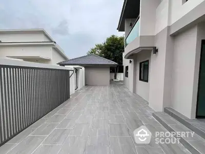 Modern exterior view of a stylish residential property with spacious tiled patio and sleek architecture.