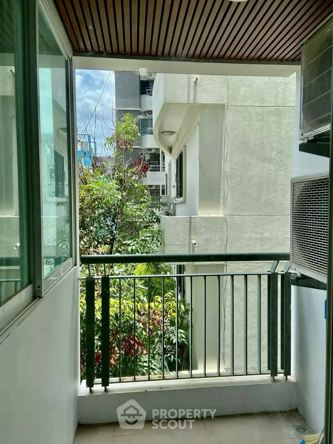 Charming balcony with lush greenery and modern railing, perfect for relaxation.