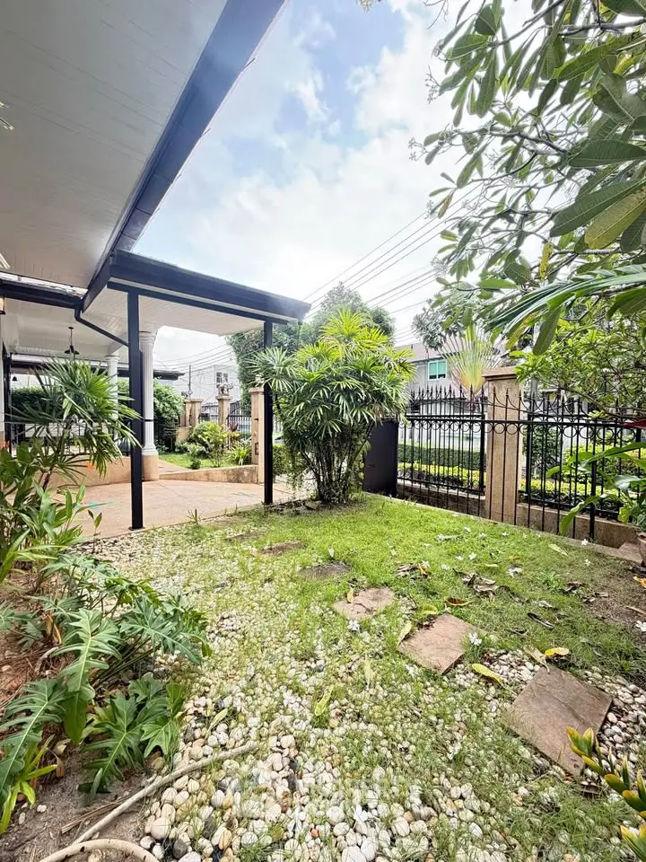 Charming garden view with lush greenery and modern fence in a serene residential area.