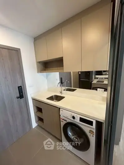 Modern compact kitchen with washing machine and sleek cabinetry
