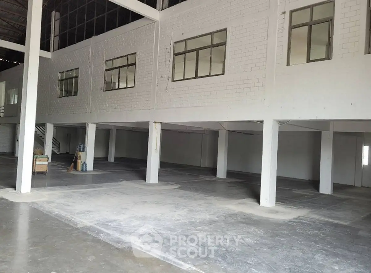 Spacious industrial warehouse with high ceilings and ample natural light.