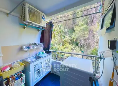 Charming balcony with lush greenery view and modern appliances