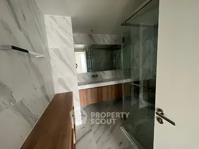 Modern bathroom with marble tiles and glass shower enclosure