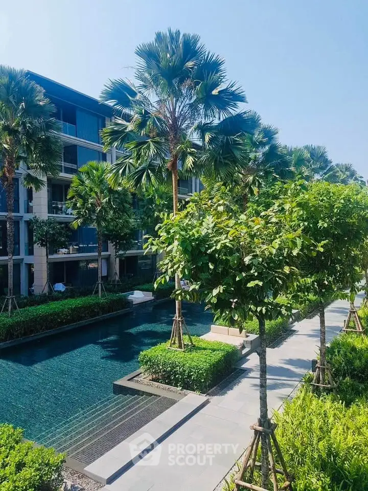 Luxurious residential complex with lush greenery and inviting swimming pool.