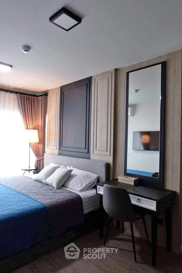 Modern bedroom with stylish decor and natural light, featuring a cozy bed and elegant desk setup.