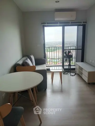 Modern living room with balcony view, featuring sleek furniture and natural light.