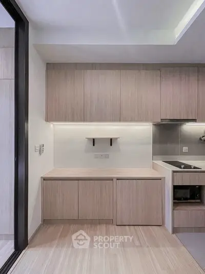 Modern kitchen with sleek cabinetry and built-in oven in a stylish apartment.