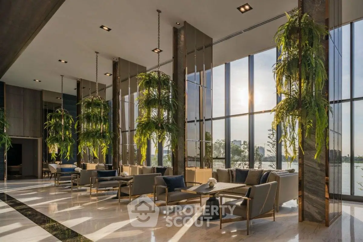 Luxurious modern lobby with floor-to-ceiling windows and lush greenery, offering a stunning river view.