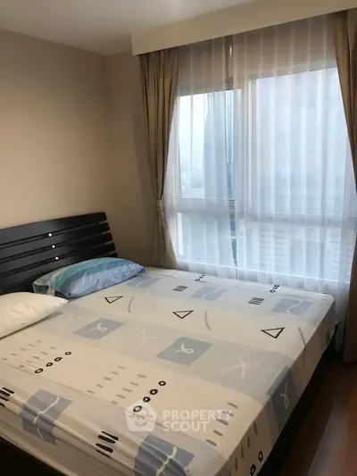Cozy bedroom with large window and modern decor in a stylish apartment.