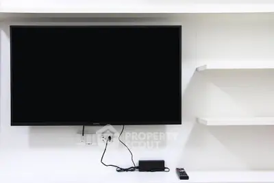 Modern living room with wall-mounted TV and sleek white shelves