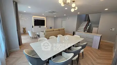 Luxurious open-plan living and dining area with modern decor and elegant lighting.