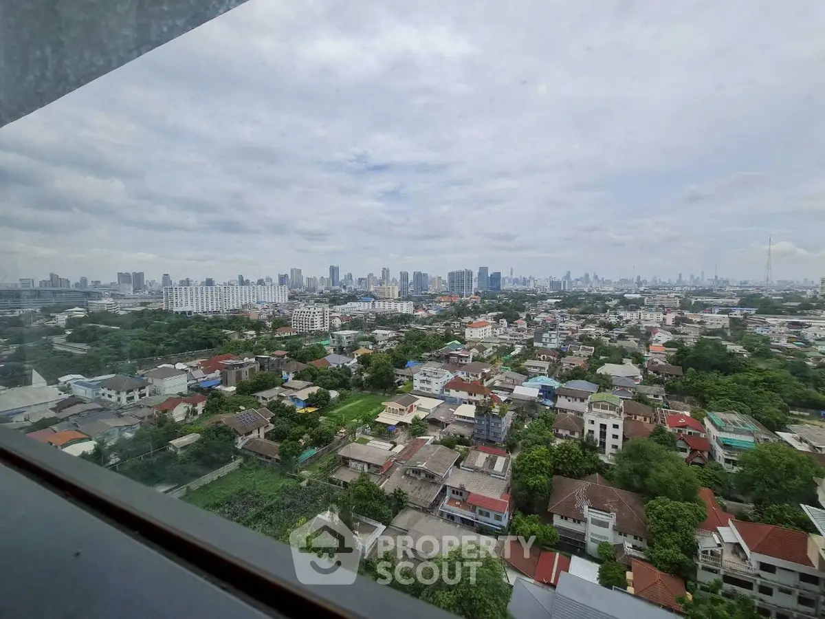 Stunning cityscape view from high-rise window showcasing urban skyline and residential area.