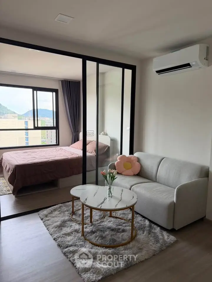Modern apartment with cozy living room and bedroom, featuring stylish decor and natural light.