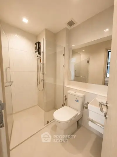 Modern bathroom with glass shower and sleek fixtures in a contemporary apartment.
