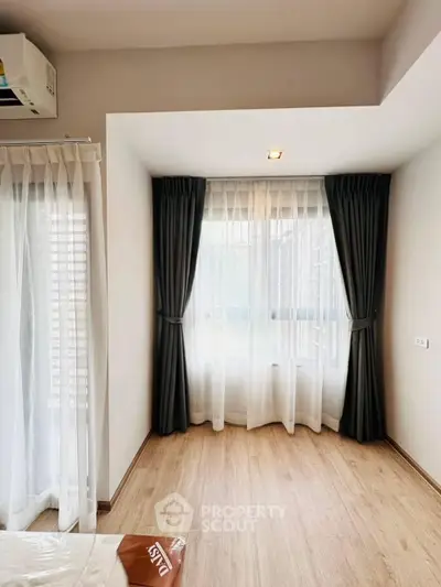 Bright corner unit with large windows and elegant curtains in a modern apartment.