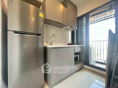 Modern kitchen with sleek appliances and balcony access in a stylish apartment.