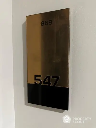 Modern apartment number plaque with sleek design and metallic finish