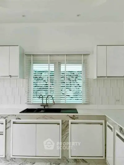 Modern kitchen with sleek white cabinets and marble countertops