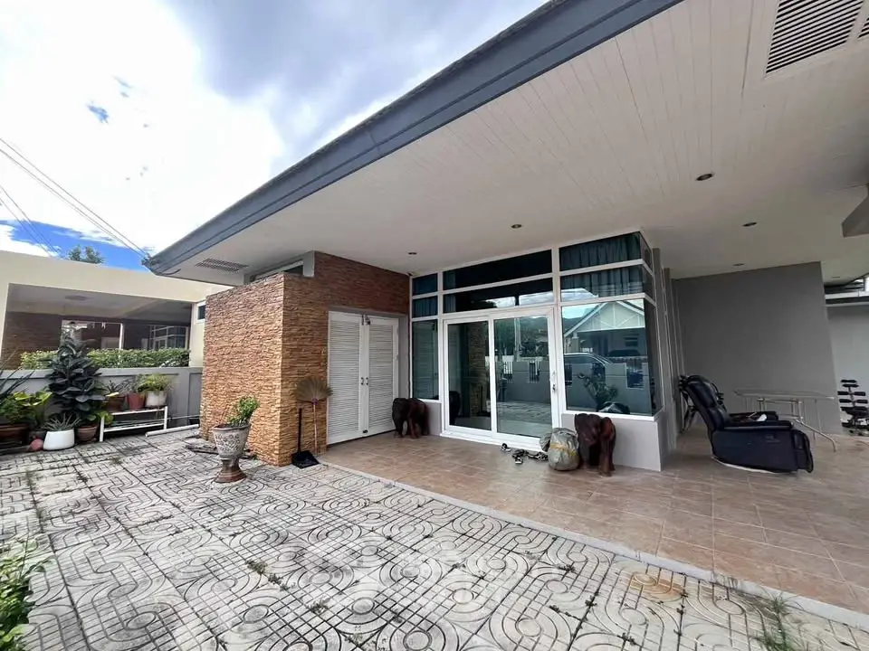 Modern home exterior with spacious patio and large windows, perfect for outdoor relaxation.