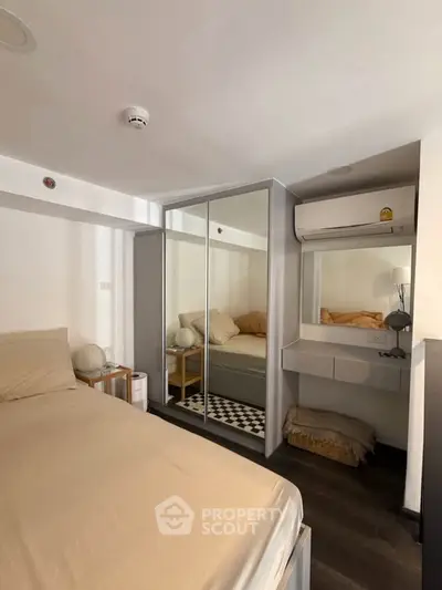 Cozy bedroom with mirrored wardrobe and air conditioning in modern apartment.