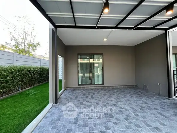 Spacious modern patio with tiled flooring and garden view.