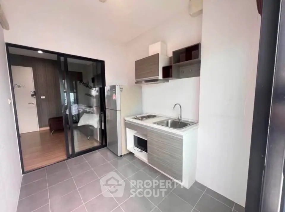 Modern open-layout kitchen with sleek appliances and adjacent bedroom view.