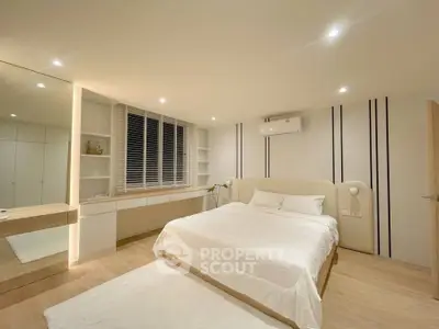 Spacious modern bedroom with elegant lighting and built-in storage, featuring a cozy bed and sleek design.