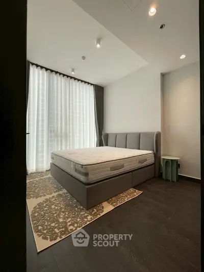 Spacious bedroom with large window and elegant decor