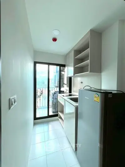 Compact kitchen with modern appliances and balcony view