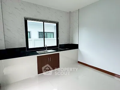 Modern kitchen with sleek design and large window for natural light.