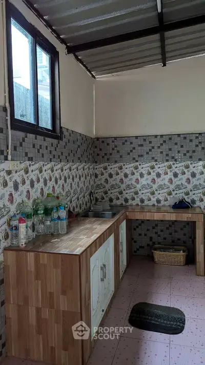 Charming kitchen with rustic wooden countertops and tiled backsplash, perfect for cozy home cooking.