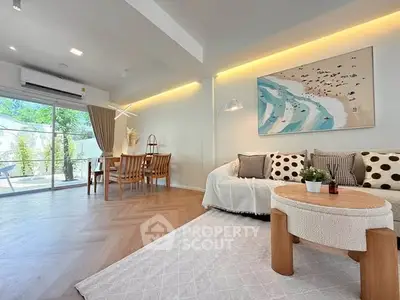 Spacious living room with modern decor and natural light, featuring a cozy seating area and stylish dining space.