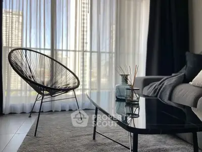 Stylish modern living room with floor-to-ceiling windows and chic furniture.